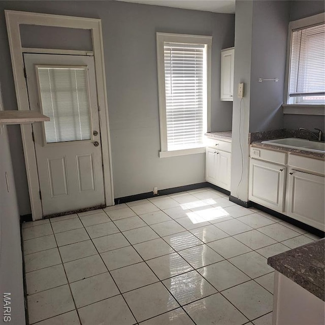 6336 Laura Ave, Saint Louis, MO 63136 - doorway to outside with light tile patterned floors, a sink, plenty of natural light, and baseboards