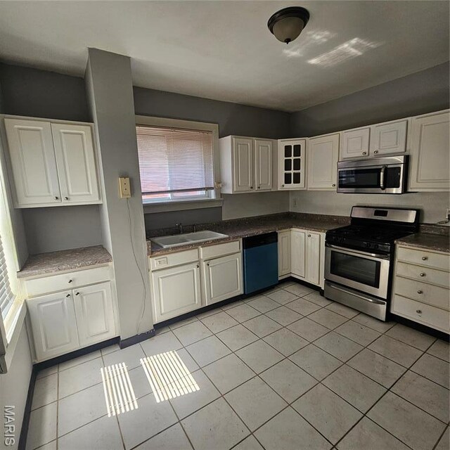 6336 Laura Ave, Saint Louis, MO 63136 - kitchen with appliances with stainless steel finishes, a sink, and light tile patterned floors