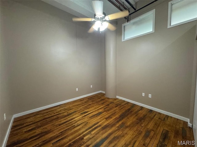 spare room featuring dark wood-style flooring, baseboards, and ceiling fan