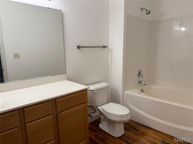 bathroom with wood finished floors, toilet, vanity, and shower / bathtub combination