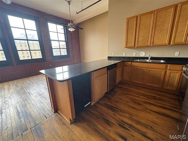 kitchen with stainless steel dishwasher, a sink, dark wood-type flooring, a peninsula, and a ceiling fan