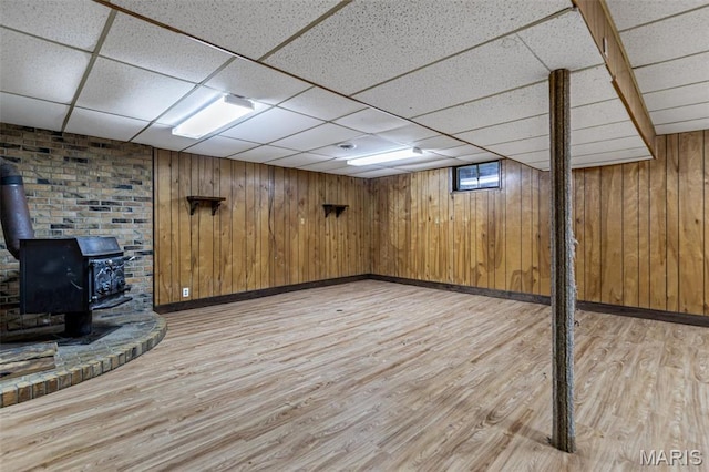 10179 Cherry Hill Ln, Potosi, MO 63664 - finished basement featuring light wood-type flooring, a drop ceiling, baseboards, a wood stove, and wooden walls