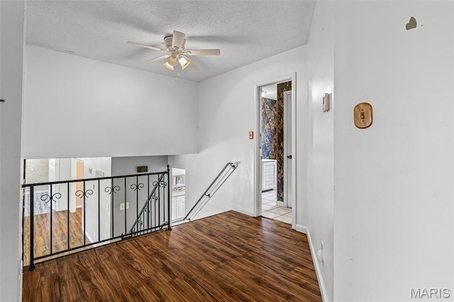 10179 Cherry Hill Ln, Potosi, MO 63664 - hallway with an upstairs landing, wood finished floors, a textured ceiling, and baseboards