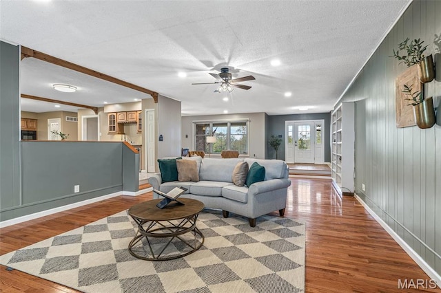 1304 Napoleon Dr, Bonne Terre, MO 63628 - living area with wood finished floors, a ceiling fan, baseboards, wooden walls, and a textured ceiling