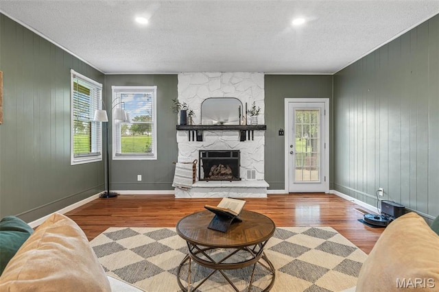 1304 Napoleon Dr, Bonne Terre, MO 63628 - living area with wood finished floors, a textured ceiling, plenty of natural light, a fireplace, and crown molding