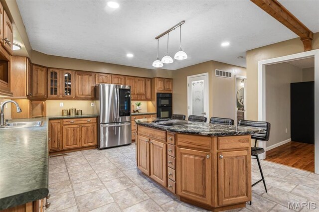 1304 Napoleon Dr, Bonne Terre, MO 63628 - kitchen featuring smart refrigerator, a sink, brown cabinets, a kitchen island, and a breakfast bar area