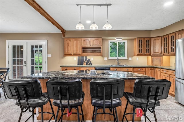 1304 Napoleon Dr, Bonne Terre, MO 63628 - kitchen featuring a sink, french doors, glass insert cabinets, dark stone countertops, and a kitchen island