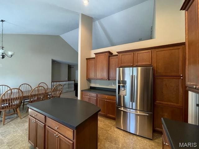 11 Summers Dr, Hawk Point, MO 63349 - kitchen featuring stainless steel fridge, dark countertops, lofted ceiling, pendant lighting, and brown cabinetry