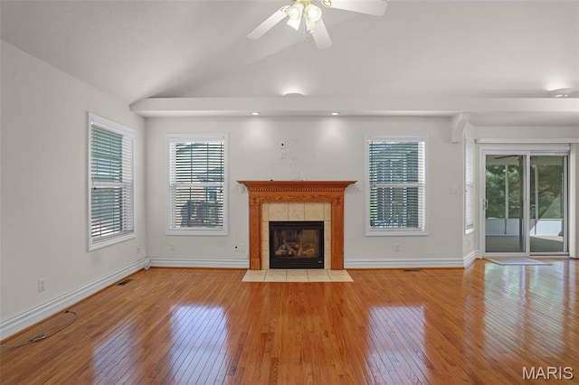 14 Berry Patch Ln, Glen Carbon, IL 62034 - unfurnished living room with light wood finished floors, healthy amount of natural light, a tile fireplace, lofted ceiling, and ceiling fan