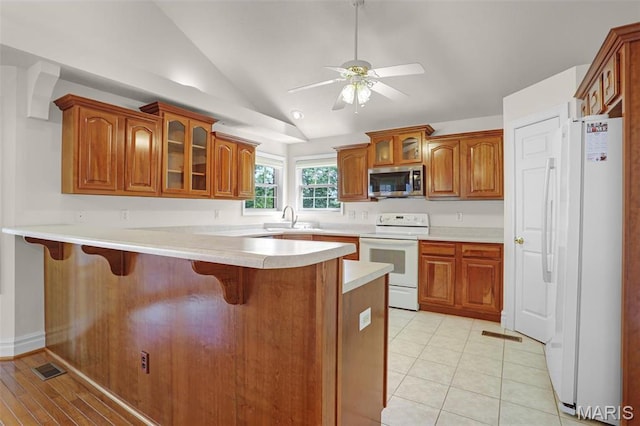 14 Berry Patch Ln, Glen Carbon, IL 62034 - kitchen featuring white appliances, lofted ceiling, a peninsula, a kitchen bar, and glass insert cabinets