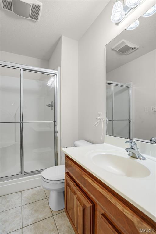 14 Berry Patch Ln, Glen Carbon, IL 62034 - full bath featuring a shower stall, tile patterned flooring, vanity, and toilet