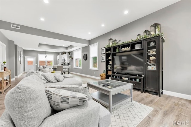 2034 Ann Ave, Saint Louis, MO 63104 - living room featuring baseboards, light wood-type flooring, recessed lighting, and a tray ceiling