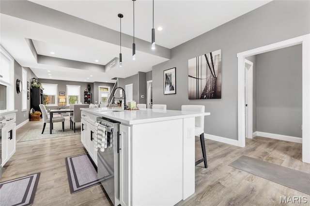 2034 Ann Ave, Saint Louis, MO 63104 - kitchen featuring stainless steel dishwasher, a sink, white cabinets, light wood-style floors, and recessed lighting