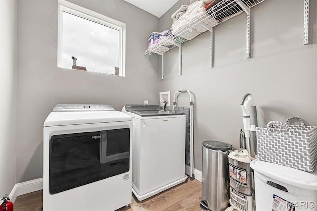 2034 Ann Ave, Saint Louis, MO 63104 - laundry area with separate washer and dryer, light wood finished floors, cabinet space, and baseboards