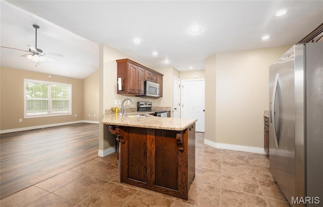 20256 Hardcastle Ln, Saint Robert, MO 65584 - kitchen with stainless steel appliances, a sink, a peninsula, ceiling fan, and light stone countertops