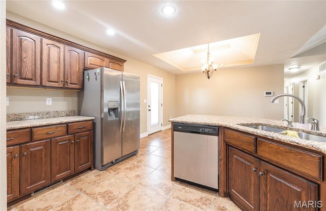 20256 Hardcastle Ln, Saint Robert, MO 65584 - kitchen with stainless steel appliances, a sink, a raised ceiling, a chandelier, and light tile patterned floors