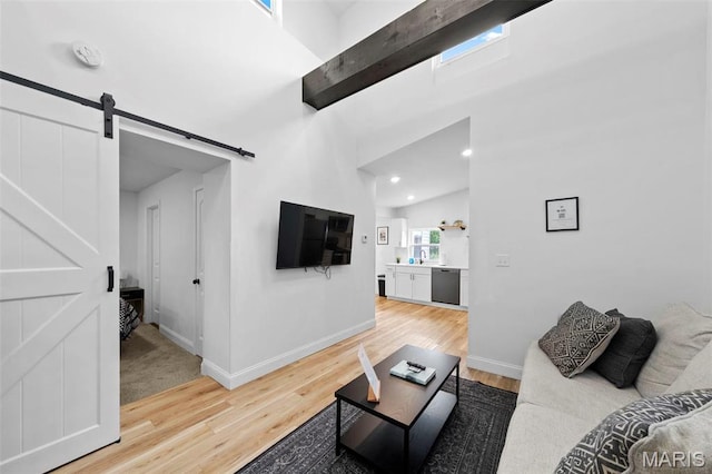 1326 Graham St, Saint Louis, MO 63139 - living area featuring a barn door, light wood-style flooring, baseboards, a towering ceiling, and recessed lighting