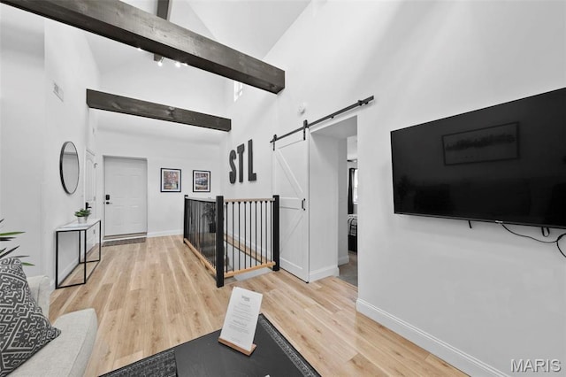 1326 Graham St, Saint Louis, MO 63139 - hallway with a barn door, high vaulted ceiling, light wood-style flooring, baseboards, and beamed ceiling