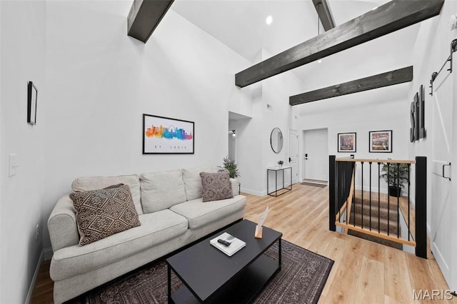 1326 Graham St, Saint Louis, MO 63139 - living room with beam ceiling, wood finished floors, high vaulted ceiling, baseboards, and a barn door
