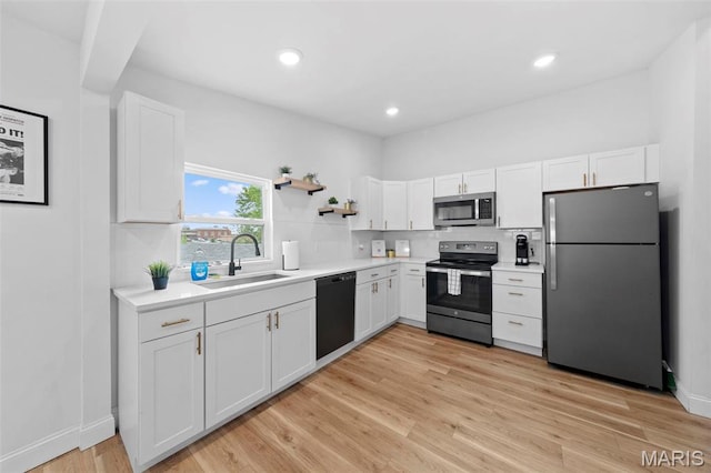 1326 Graham St, Saint Louis, MO 63139 - kitchen with stainless steel appliances, a sink, white cabinetry, and recessed lighting