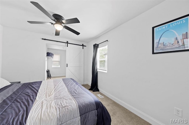 1326 Graham St, Saint Louis, MO 63139 - carpeted bedroom with a barn door, baseboards, and a ceiling fan