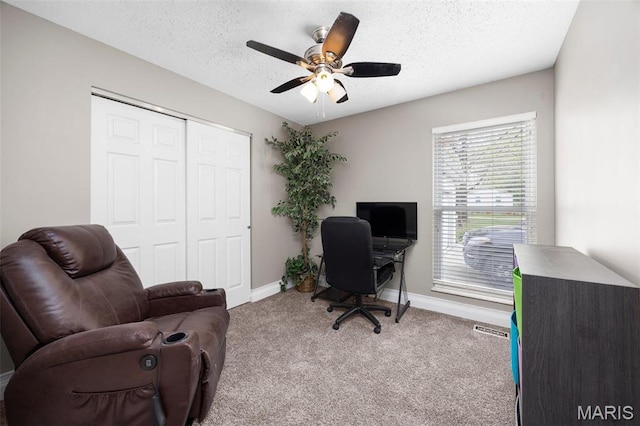 carpeted office with baseboards, a ceiling fan, and a textured ceiling