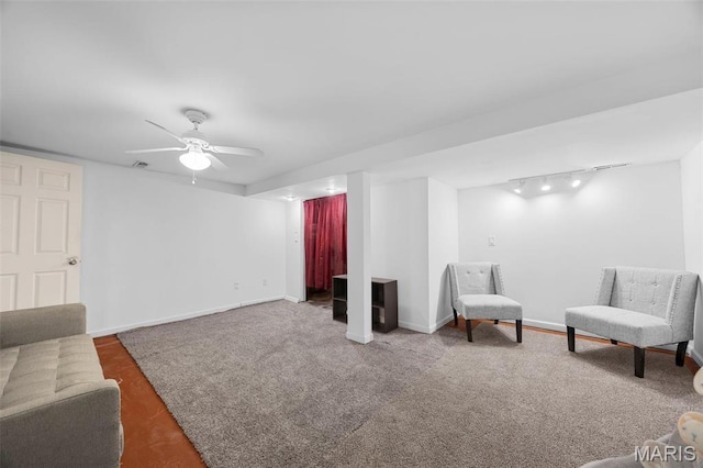 living area with carpet flooring, track lighting, baseboards, and ceiling fan