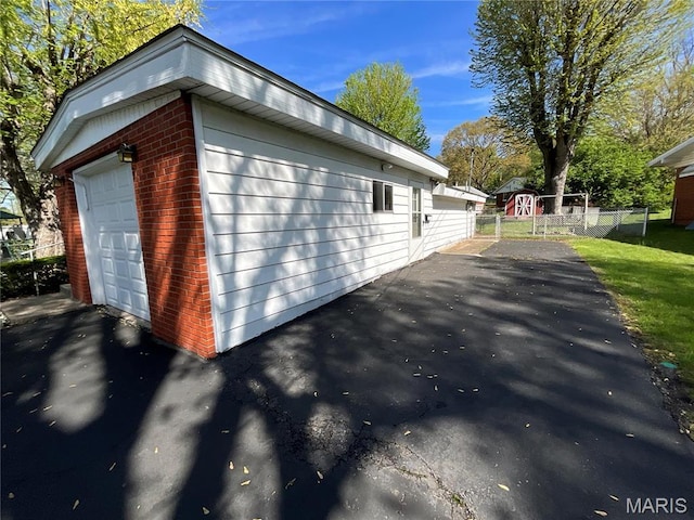 805 Willoway Ave, East Alton, IL 62024 - view of side of home featuring fence, brick siding, an outdoor structure, driveway, and a garage