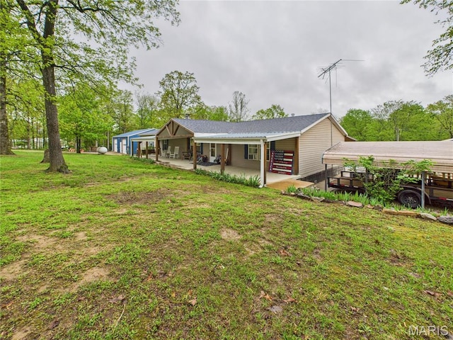 back of house with a yard and a patio