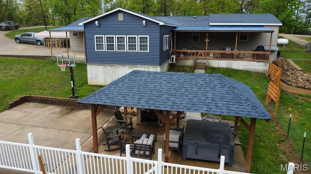 back of property with a gazebo, a patio area, and view of scattered trees