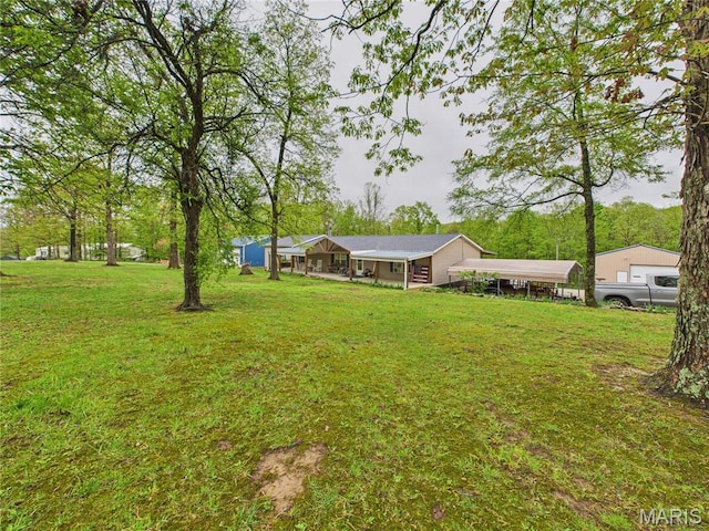view of grassy yard with a carport