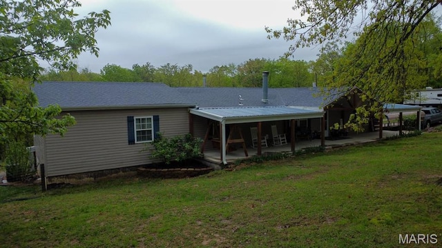 rear view of property featuring a lawn and a patio