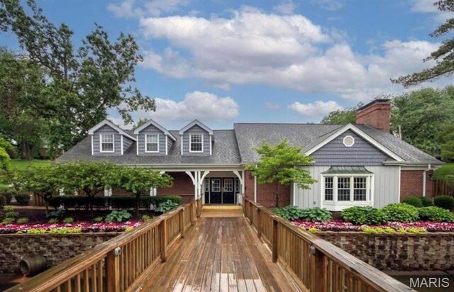 9162 Eager Rd, Saint Louis, MO 63144 - back of house with a chimney, board and batten siding, and brick siding