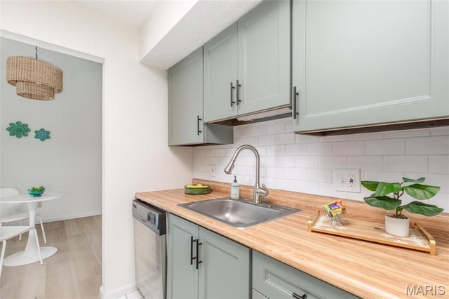 9162 Eager Rd, Saint Louis, MO 63144 - kitchen featuring dishwasher, a sink, light countertops, tasteful backsplash, and baseboards