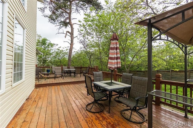 deck with outdoor dining space and a fenced backyard