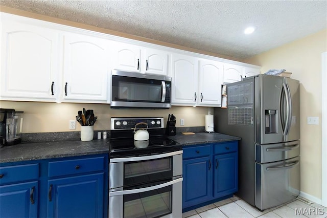 kitchen featuring stainless steel appliances, blue cabinetry, dark countertops, recessed lighting, and a textured ceiling