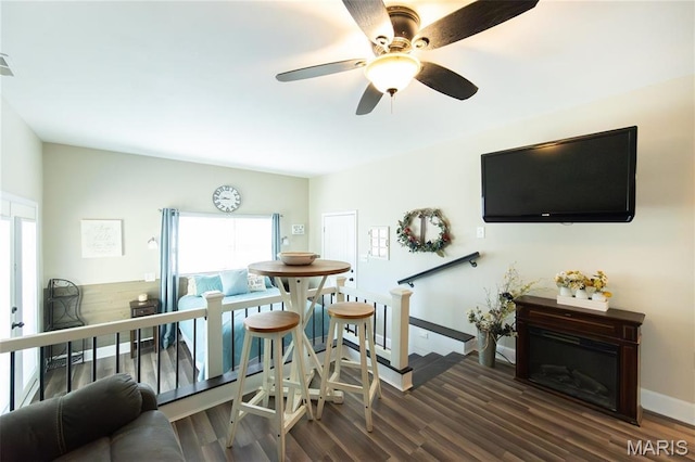 living room with healthy amount of natural light, wood finished floors, baseboards, and a ceiling fan