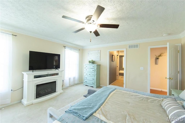 bedroom with a textured ceiling, carpet flooring, a glass covered fireplace, crown molding, and a ceiling fan