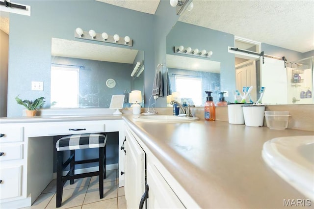 full bath featuring a textured ceiling, a stall shower, double vanity, and tile patterned flooring