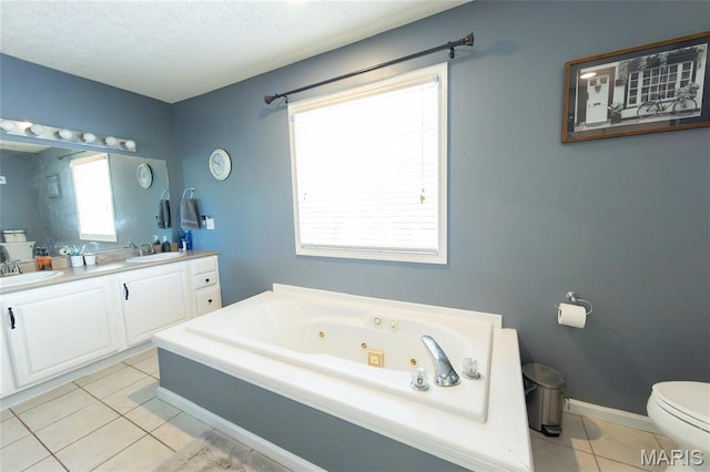 full bath featuring tile patterned floors, a whirlpool tub, a textured ceiling, toilet, and double vanity