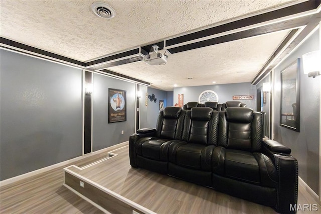 home theater with a textured ceiling, wood finished floors, and baseboards