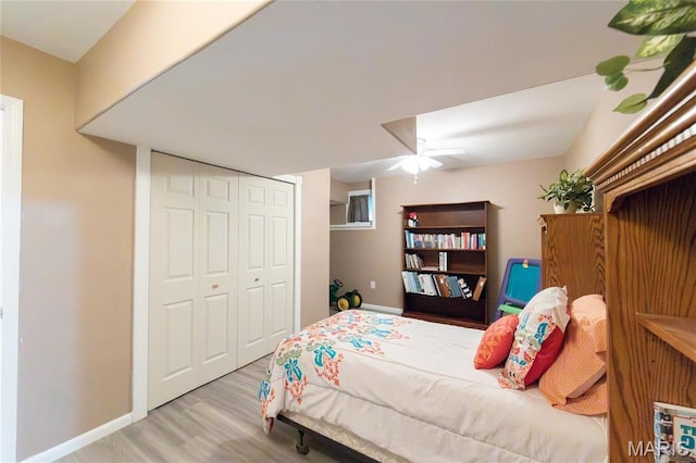 bedroom with wood finished floors, baseboards, a closet, and ceiling fan