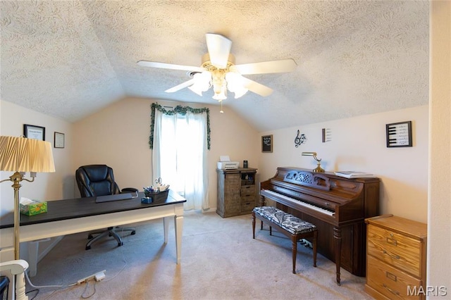 home office featuring a textured ceiling, vaulted ceiling, ceiling fan, and light colored carpet