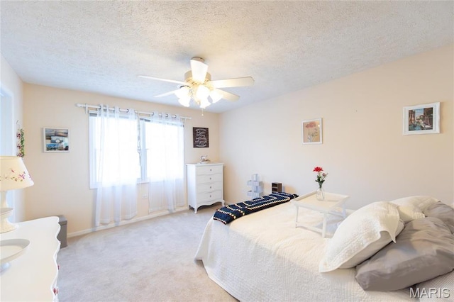 bedroom with carpet, a textured ceiling, baseboards, and ceiling fan