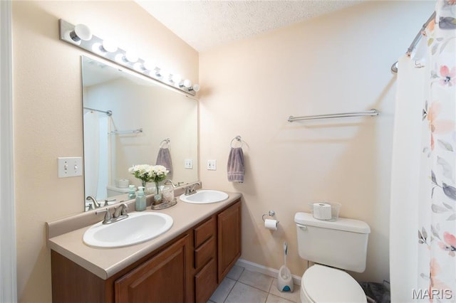 full bathroom with tile patterned flooring, toilet, double vanity, a textured ceiling, and baseboards
