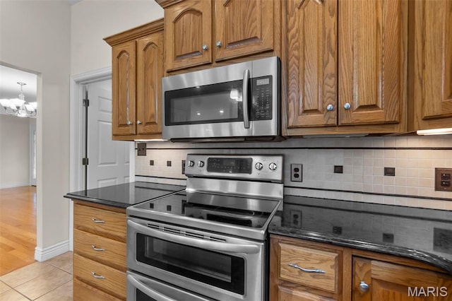 2600 Cobblestone Ct, Cape Girardeau, MO 63701 - kitchen with appliances with stainless steel finishes, a chandelier, backsplash, and brown cabinetry