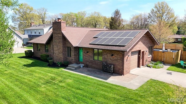 view of front of home with brick siding, a shingled roof, solar panels, and concrete driveway