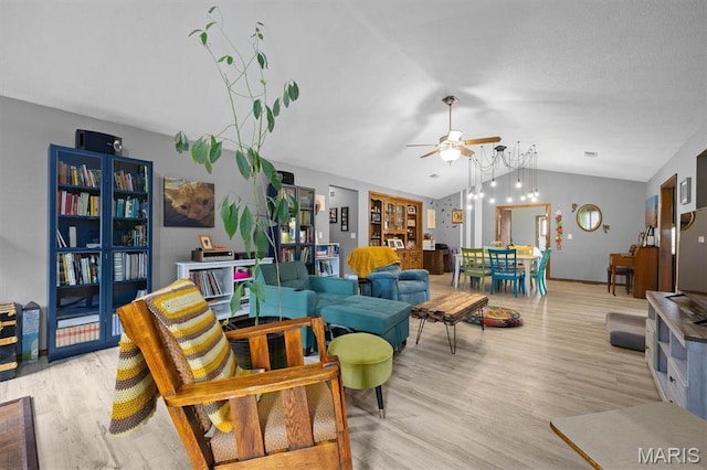 living room with vaulted ceiling, a ceiling fan, and light wood-style floors