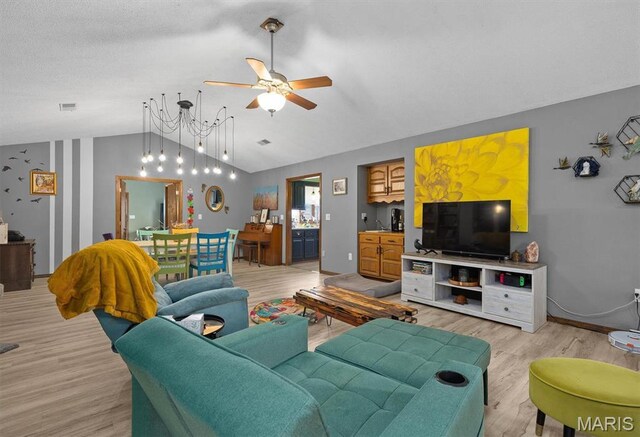 living area with light wood finished floors, vaulted ceiling, and ceiling fan