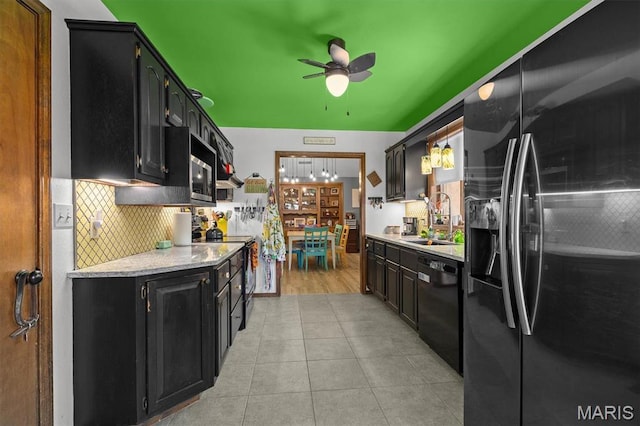 kitchen with black appliances, a sink, dark cabinets, decorative backsplash, and a ceiling fan